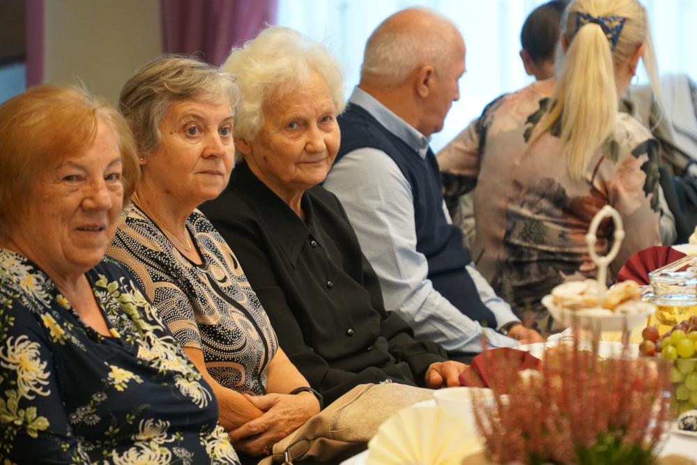 Grupa starszych osób siedząca przy stole