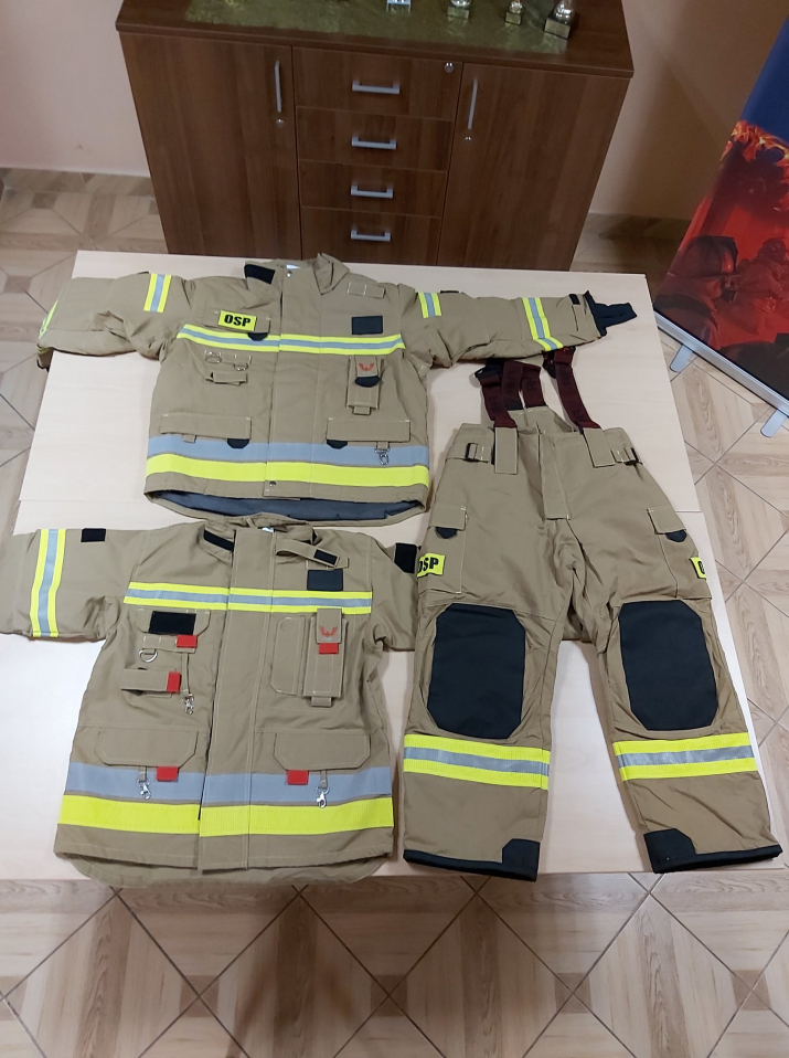 Komplety ubrań strażackich ułożone na stole