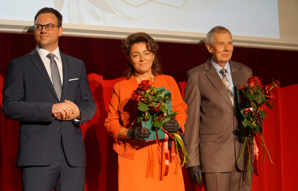 Od lewej - mężczyzna, kobieta z kwiatami i mężczyzna z kwiatami