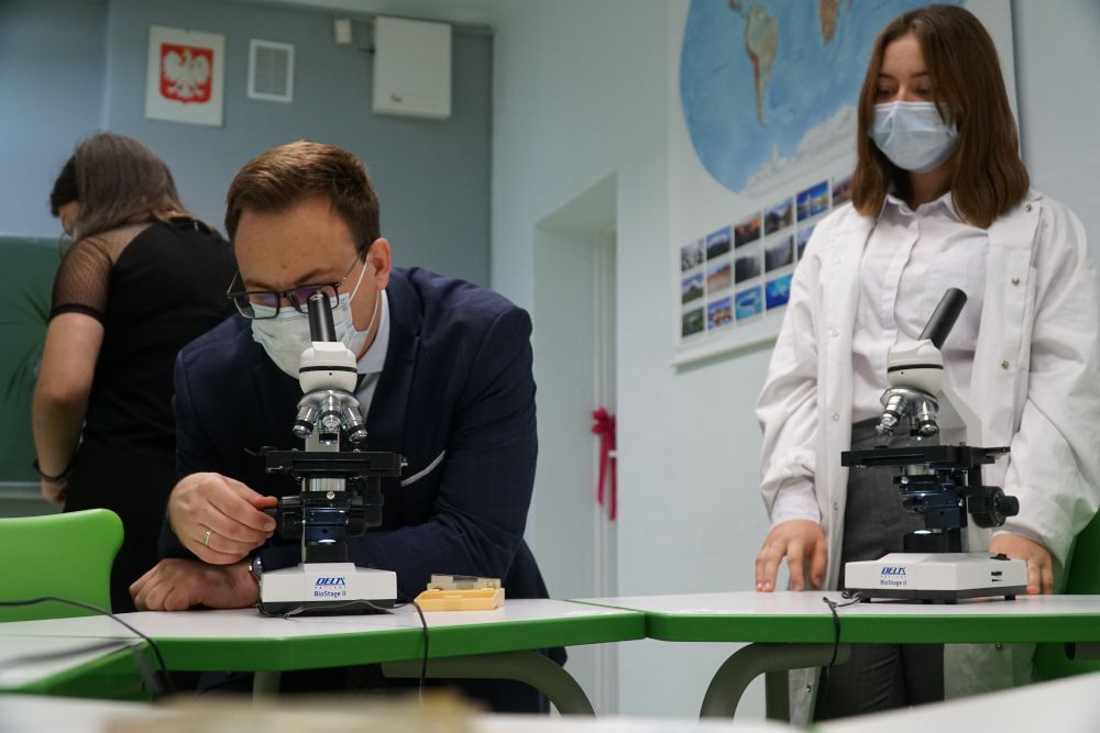 Mężczyzna i dziewczynka oglądający próbki pod mikroskopem