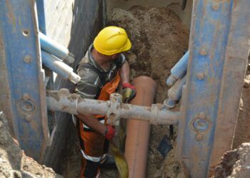 Mężczyzna w kasku podczas budowy kanalizacji sanitarnej