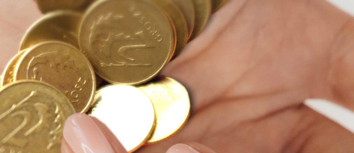 Monety - jedno i dwugroszówki trzymane w dłoni