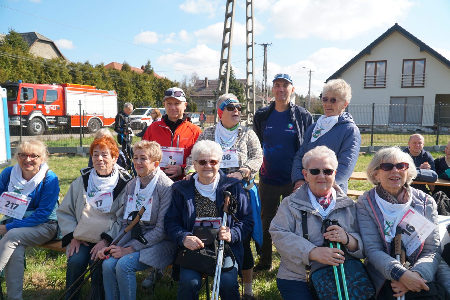 Grupa uśmiechniętych seniorów z kijkami do nordic