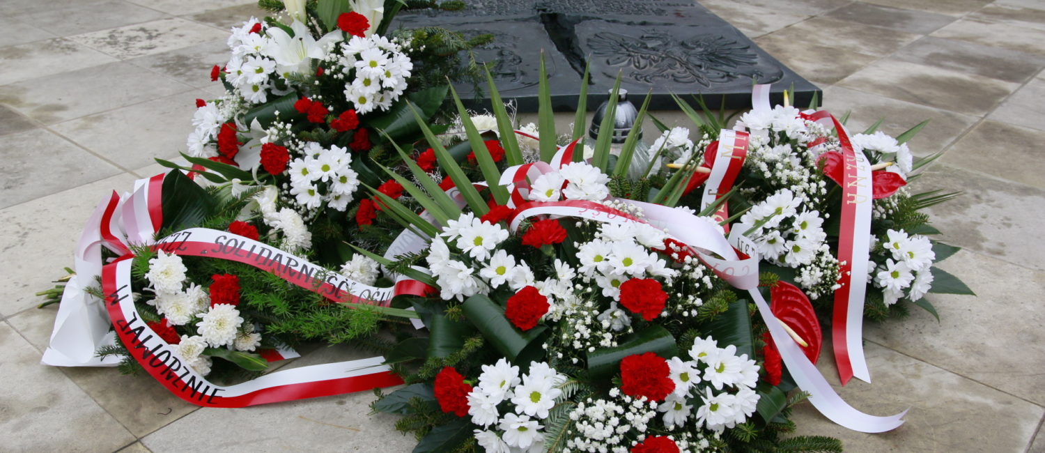 Kwiaty złożone pod pomnikiem.