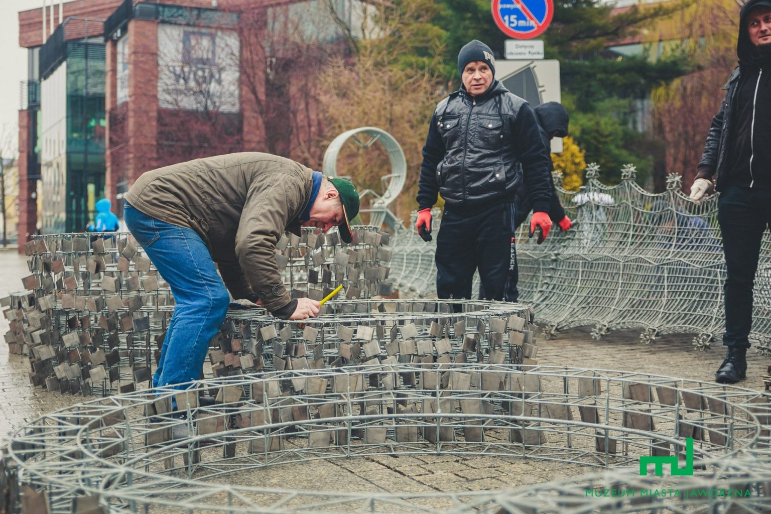 Mężczyźni montują elementy na stalowej konstrukcji