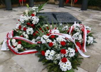 Kwiaty złożone pod pomnikiem.