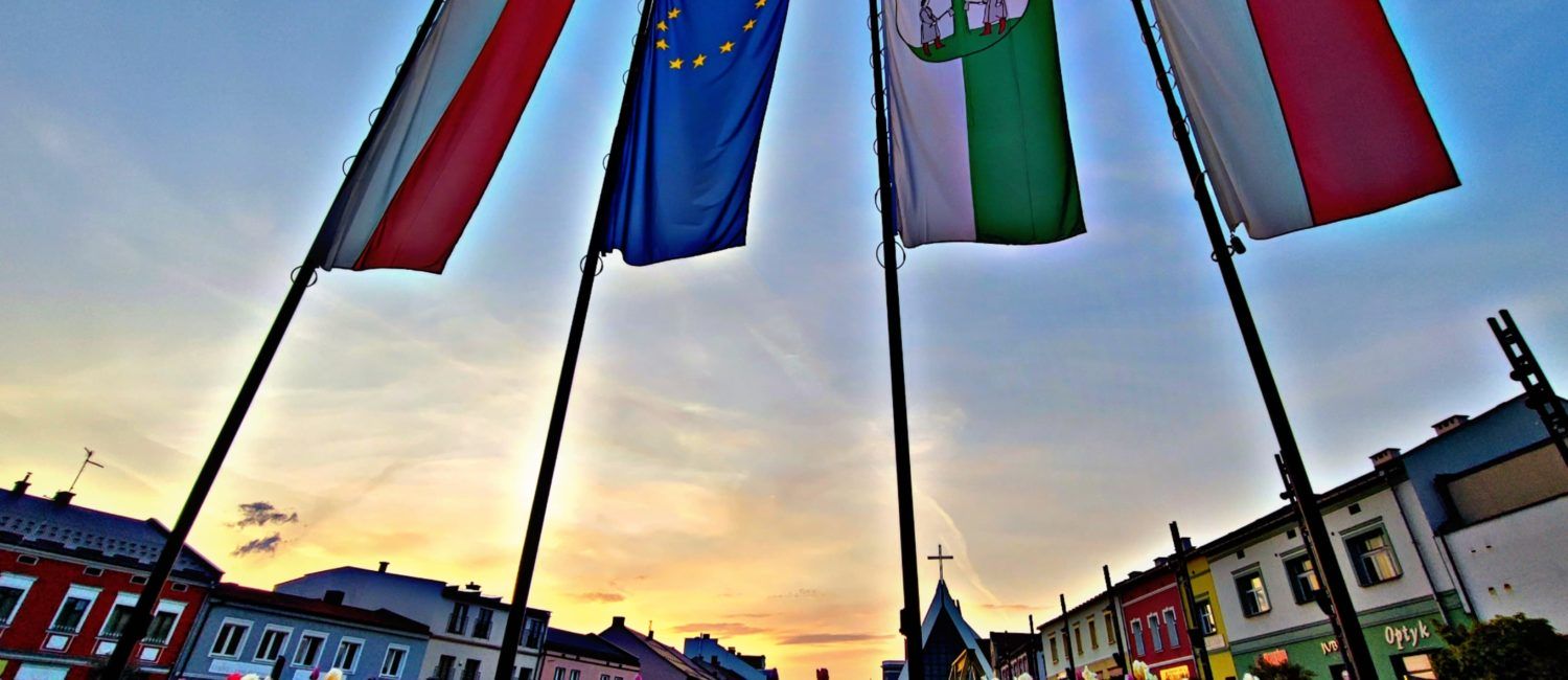 Widok na miejski rynek. na pierwszym planie flagi Polski, Unii Europejskiej i Jaworzna