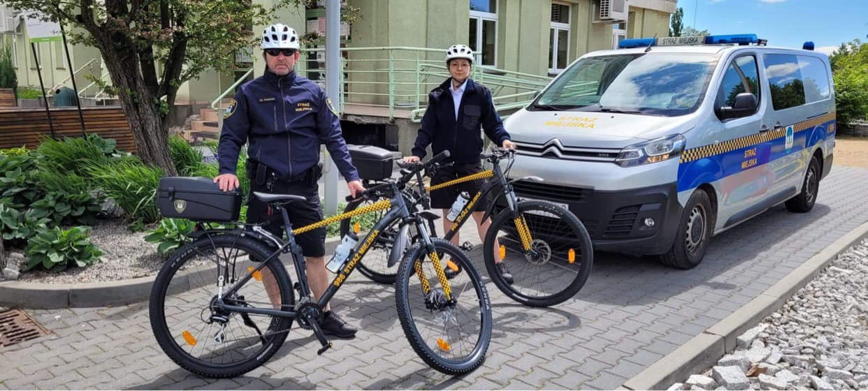 Dwaj strażnicy miejscy stojący przy rowerach
