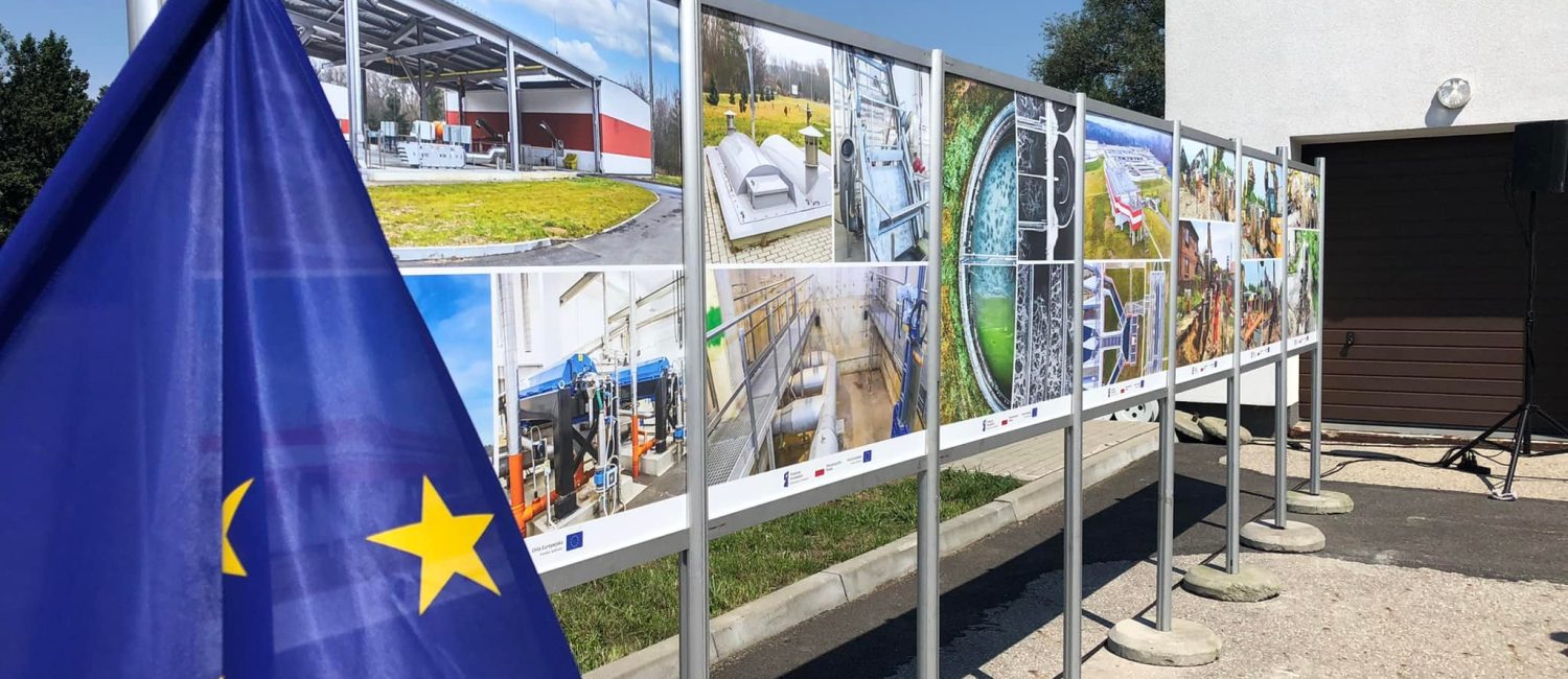 Tablica ze zdjęciami, na pierwszym planie flaga Unii Europejskiej