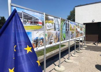 Tablica ze zdjęciami, na pierwszym planie flaga Unii Europejskiej