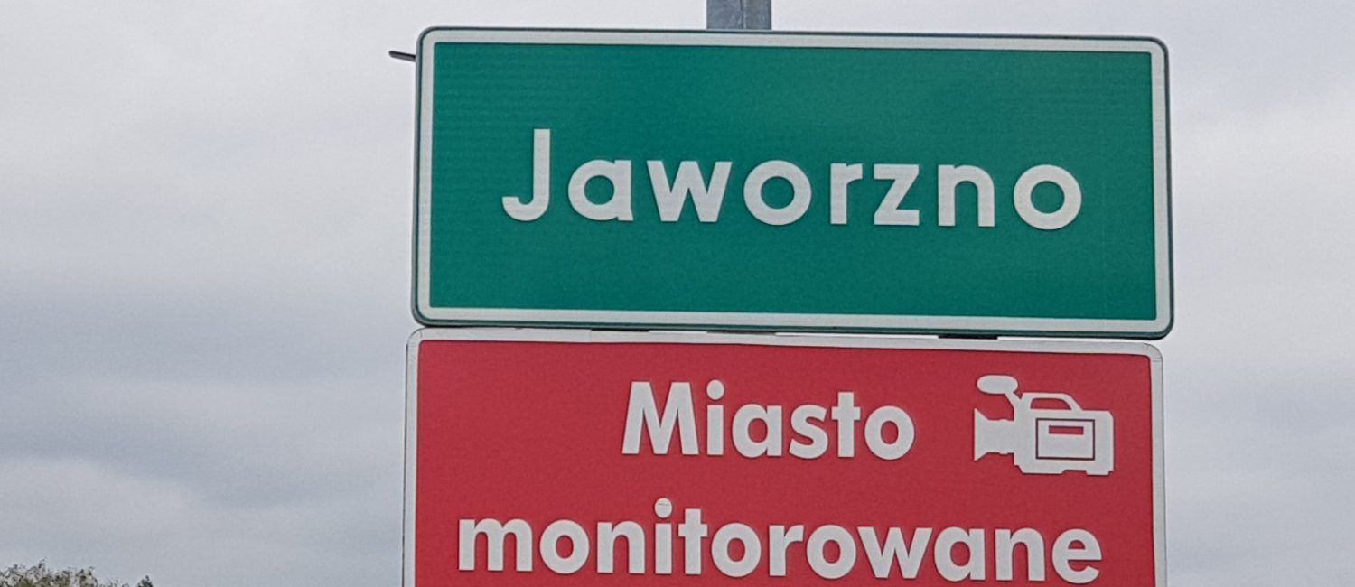 Zielona tabliczka z napisem Jaworzno oraz czerwona z napisem miasto monitorowane